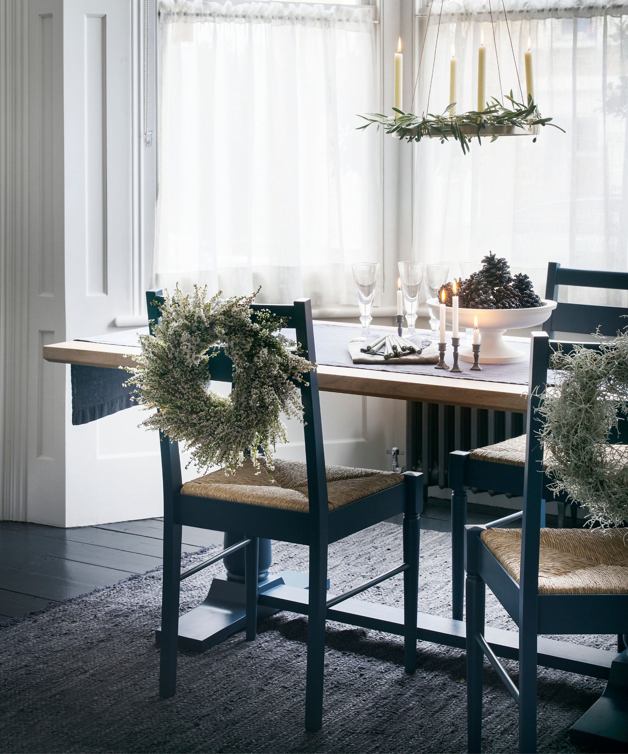 Christmas dining table with wreaths on chair backs