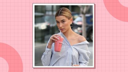 Hailey Bieber Erewhon smoothie: Hailey Bieber pictures sipping on a pink smoothie/ drink while wearing a blue striped shirt/ in a pink template