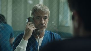 dermot mulroney answers a phone from behind bars in the thriller like father like son