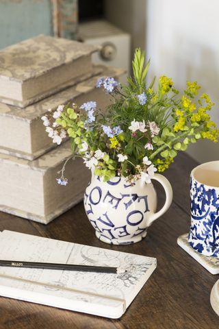 flowers in emma bridgewater jug on vintage wooden desk