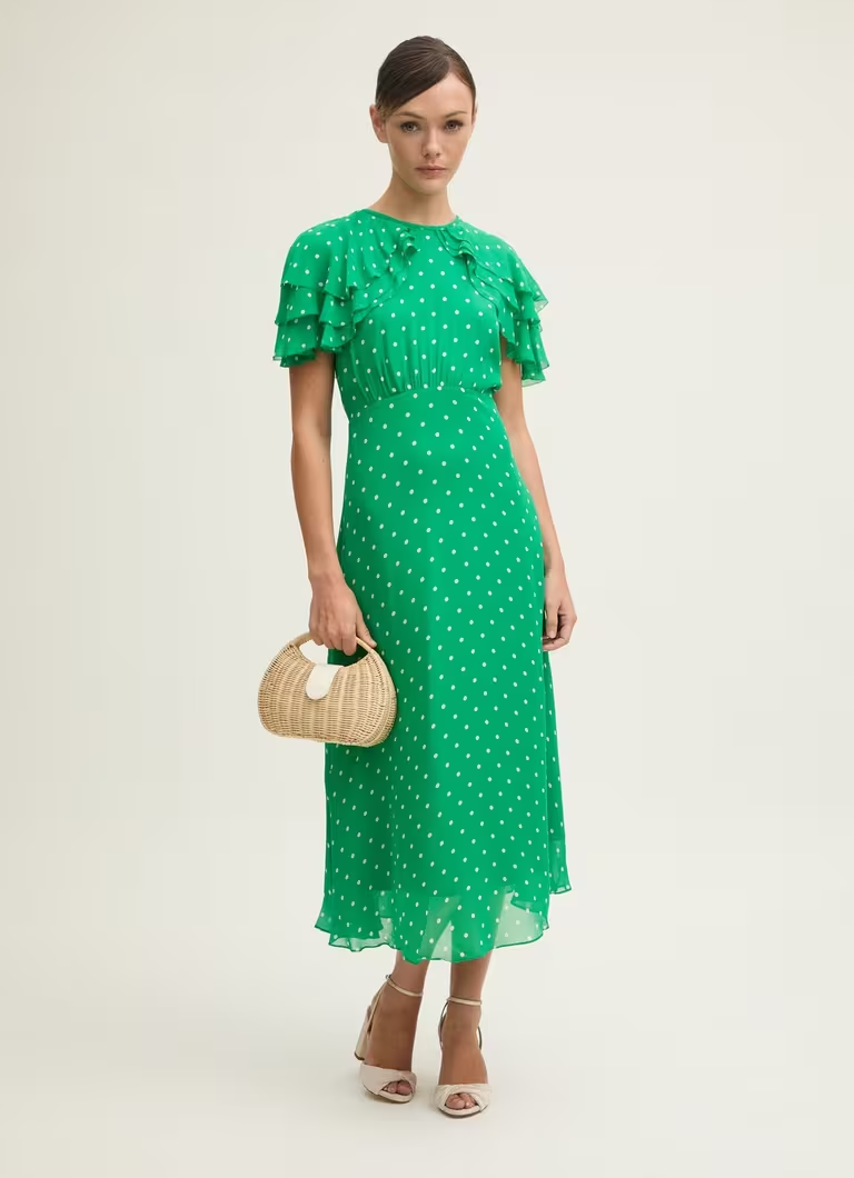 Model wearing a green polka dot dress by L.K. Bennett
