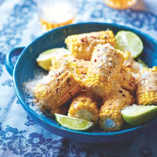 BBQ Mexican corn in blue dish with lime slices