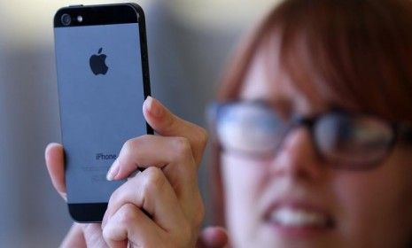 A customer inspects the new iPhone 5 at an Apple Store in San Francisco on Sept. 21