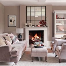 Mushroom living room with roaring fire and a window-style mirror above the fireplace