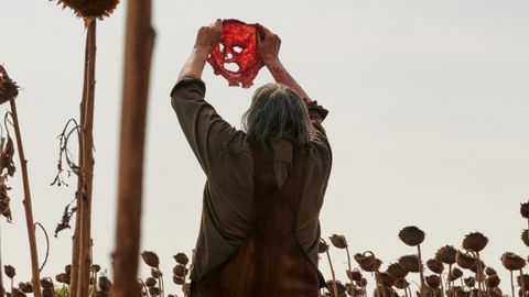 Leatherface holding skin mask up to the sky in Texas Chainsaw Massacre