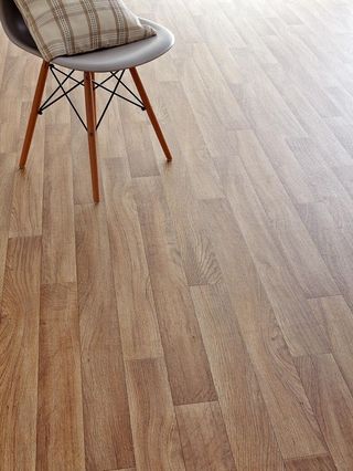 Oak-effect Vinyl Flooring with a modern plastic chair with wooden legs with a cushion on it in the top left corner
