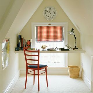 cosy desk area with watch on wall and chair