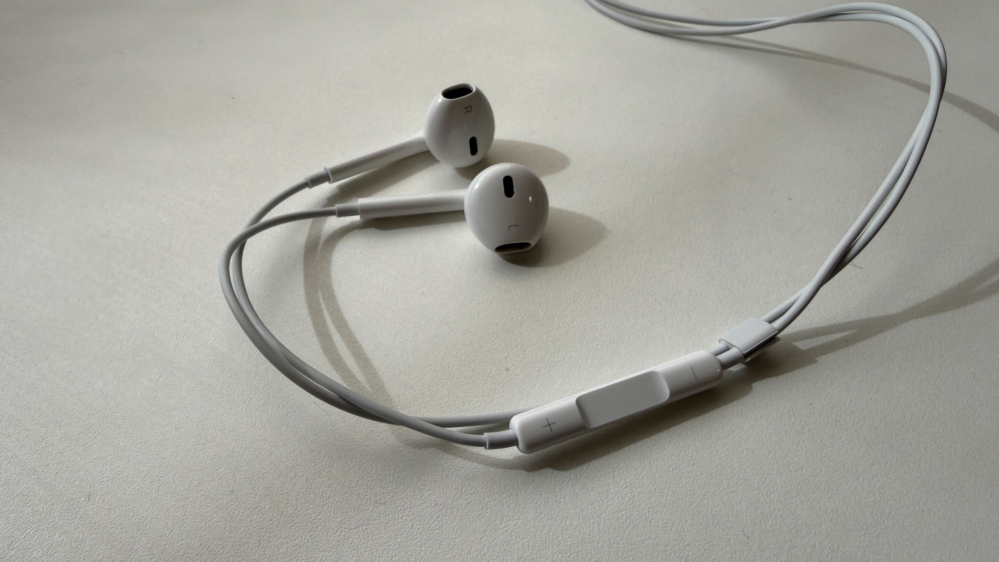 A pair of wired earbuds on a white table
