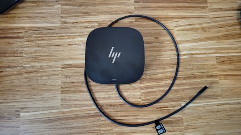 A black HP USB-C Dock G5 sitting on a wooden table
