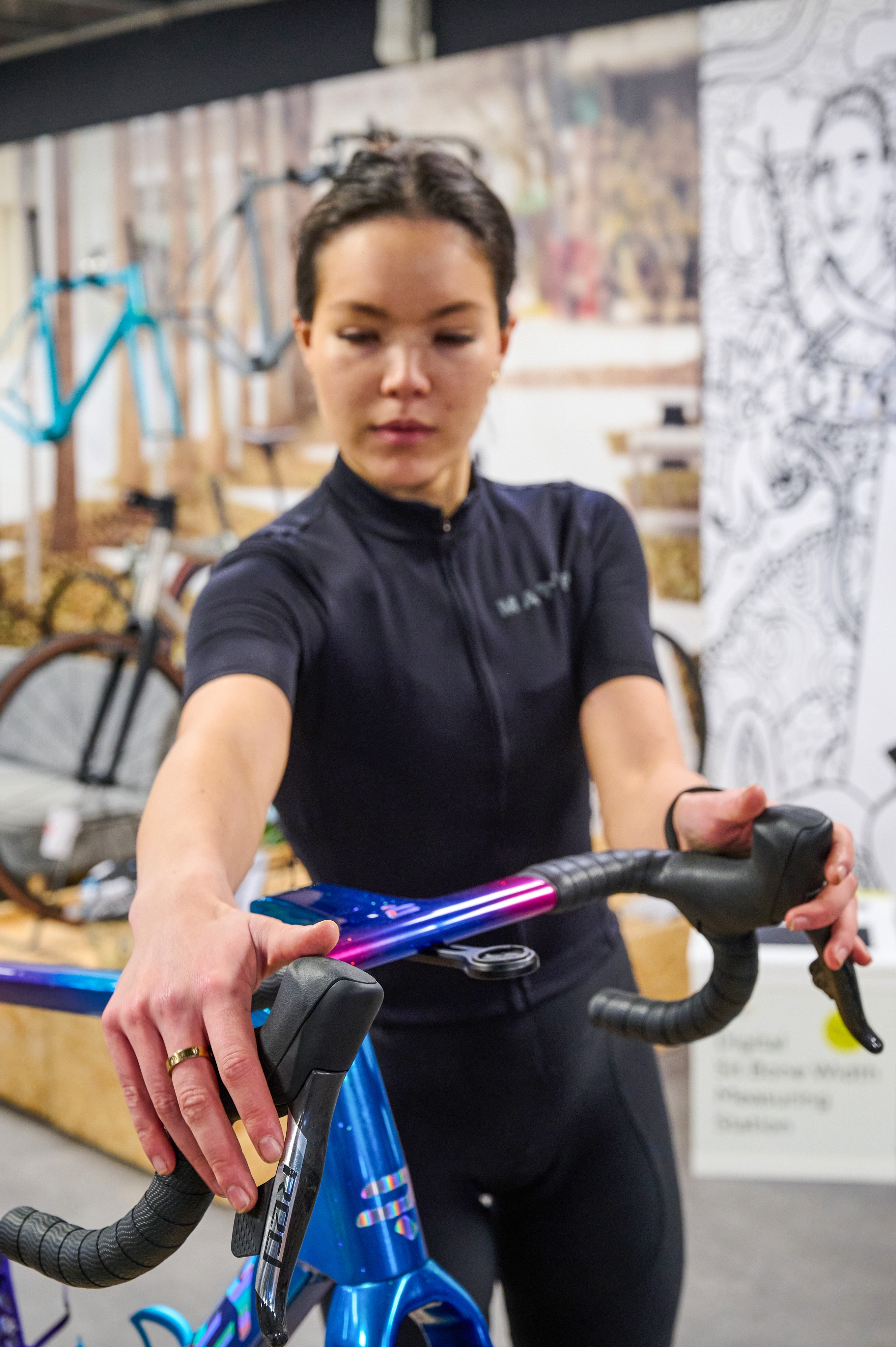 A woman in a bike shop testing handlebars