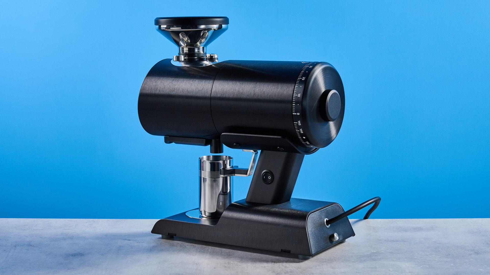 the mazzer philos coffee grinder in black and stainless steel photographed against a tom's guide blue background