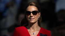 Catherine, Princess of Wales, is pictured wearing a red dress, sunglasses and with her hair up in a half-up, half-down style, whilst in the centre court royal box during the Women's Singles final on day thirteen of The Championships Wimbledon 2026 at All England Lawn Tennis and Croquet Club on July 11, 2026, in London, England.
