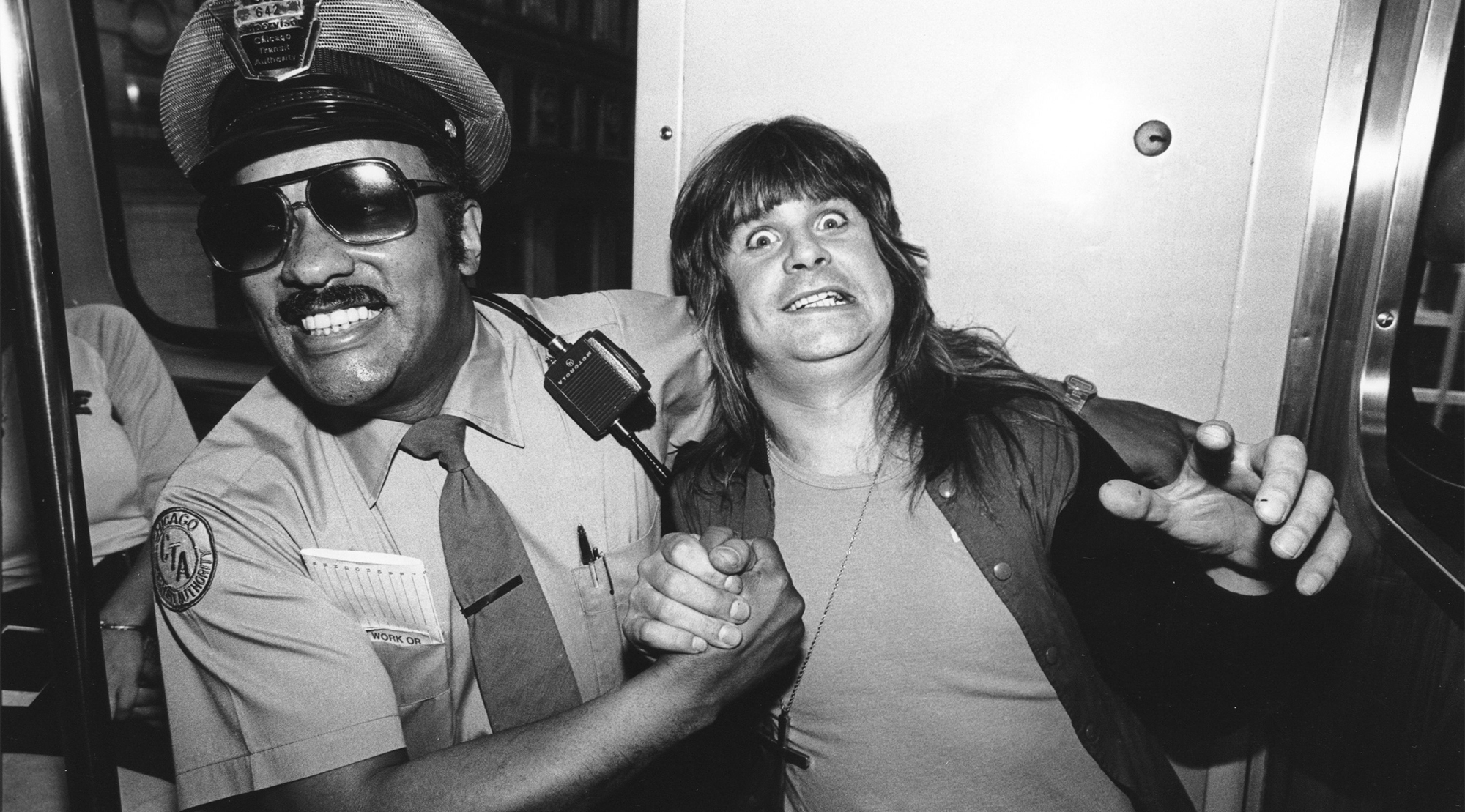 Heavy metal singer Ozzy Osbourne hams it up with a Chicago Transit Authority policeman circa 1980 in Chicago, Illinois.