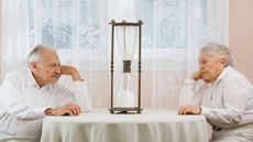 picture of elderly couple staring at an hourglass
