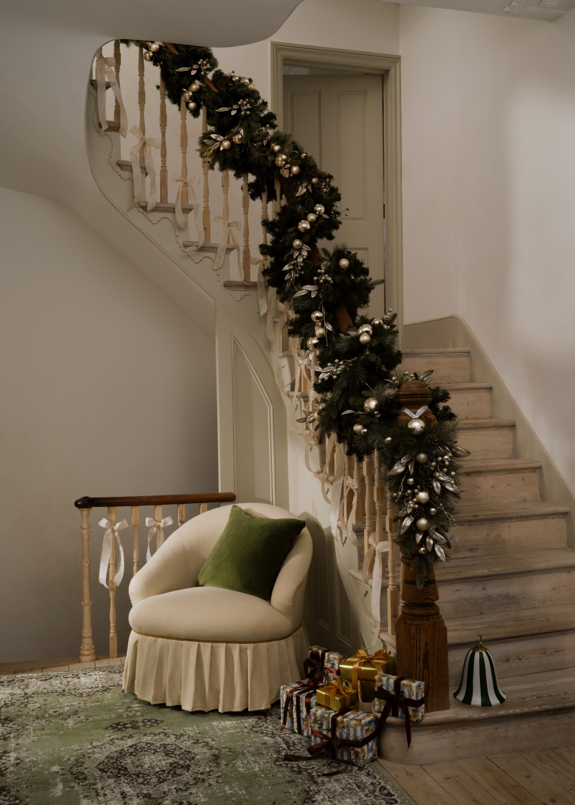 a beautiful curved staircase decorated with baubles and garlands