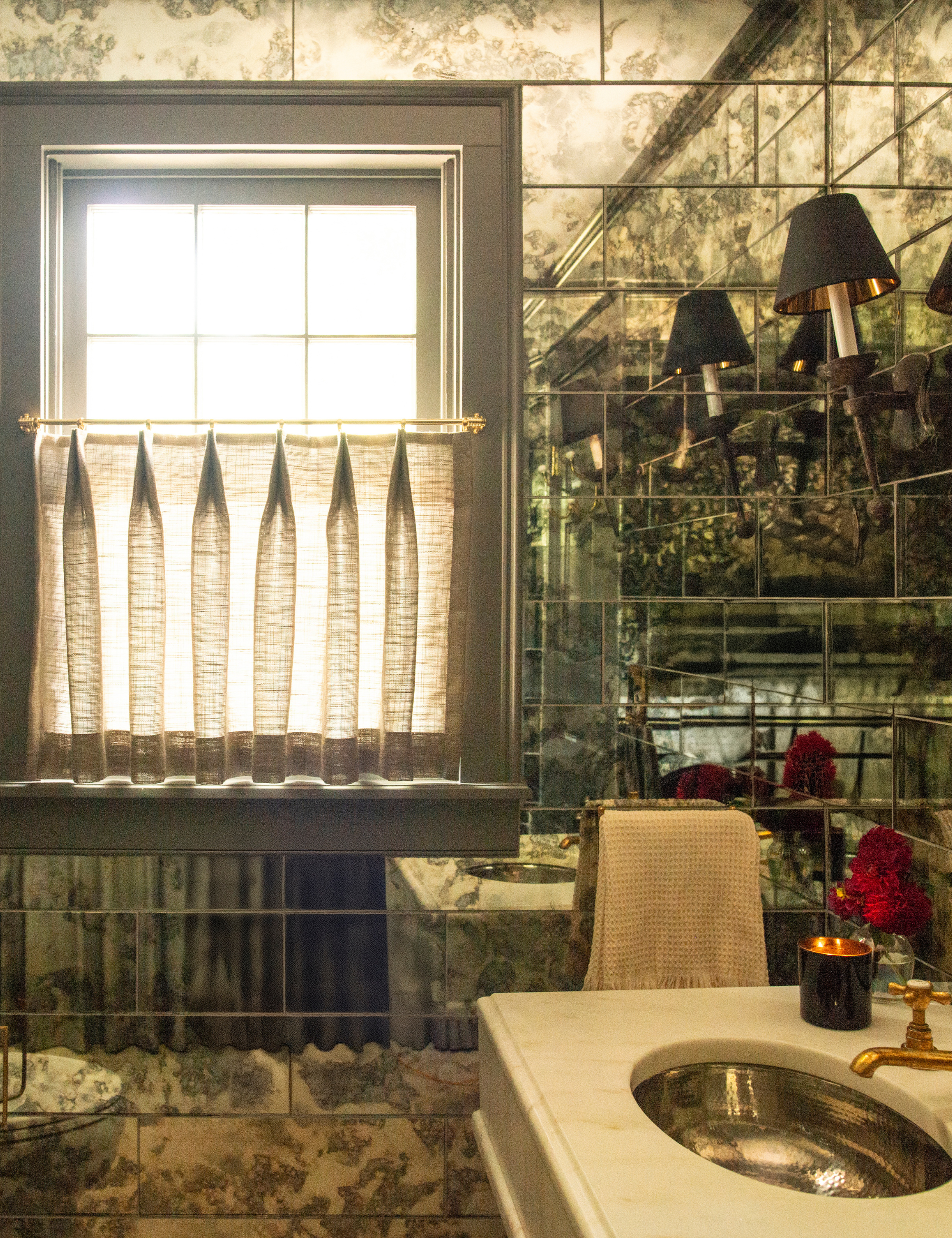 Nicole Fisher-designed mirror-tile powder room, featuring sheer cafe curtains and brass hardware