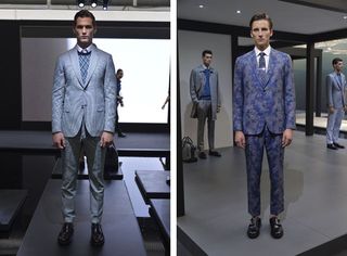 Two side-by-side photos of male models wearing looks from Brioni's collection. In the first photo the model is wearing a white shirt, blue patterned jumper, grey suit and black shoes. A person can be seen in the background. In the second photo the model is wearing a white shirt, tie, blue patterned suit and black shoes. There are two other models in suits in the background