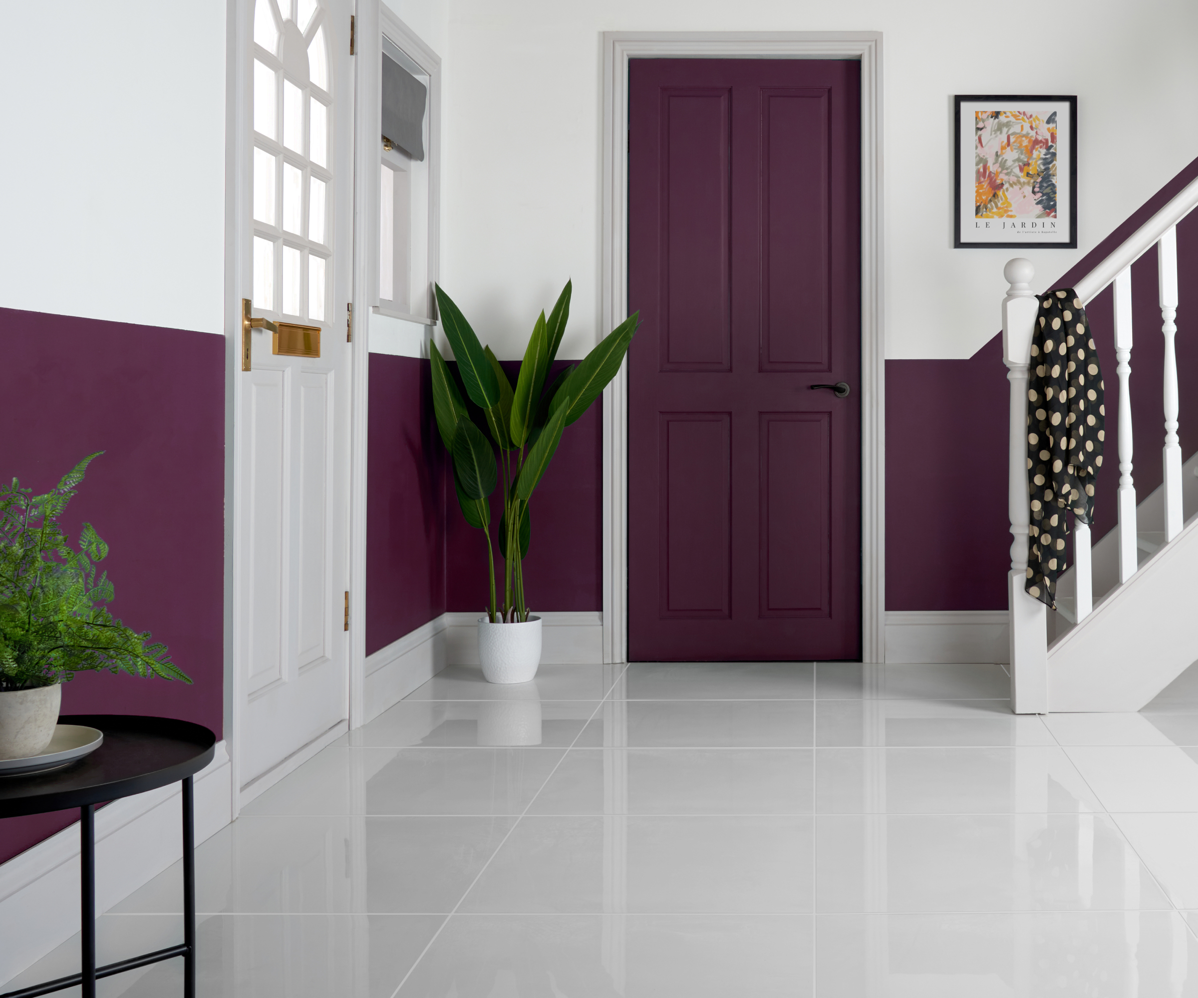 shiny white gloss floor tiles in hallway with half height purple wall panelling below white walls, purple interior doors and white staircase and front door