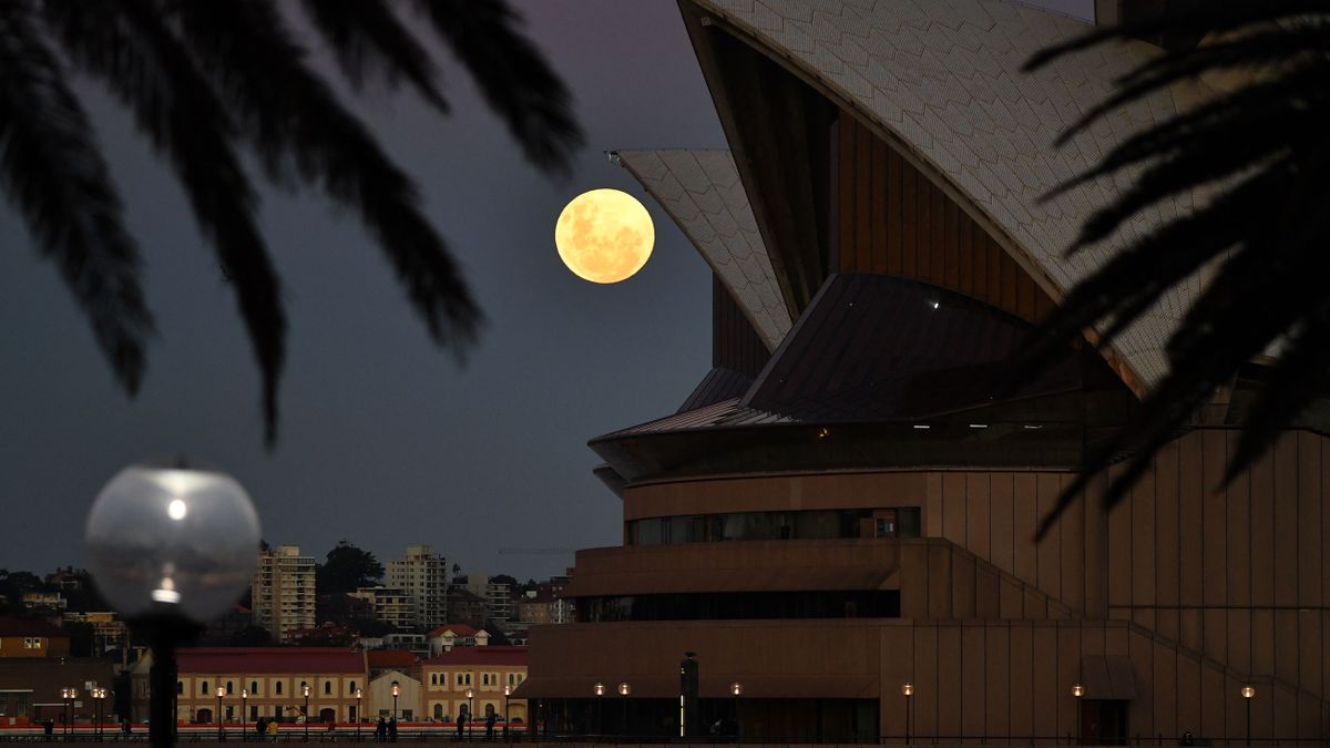 The full moon rises over Sydney's iconic opera house on May 26, 2021.