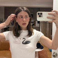 Jamie Schneider taking a mirror selfie wearing a white T-shirt 
