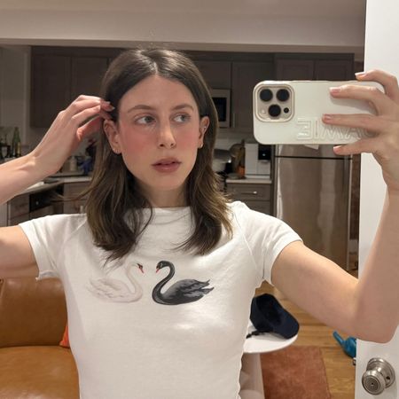 Jamie Schneider taking a mirror selfie wearing a white T-shirt 