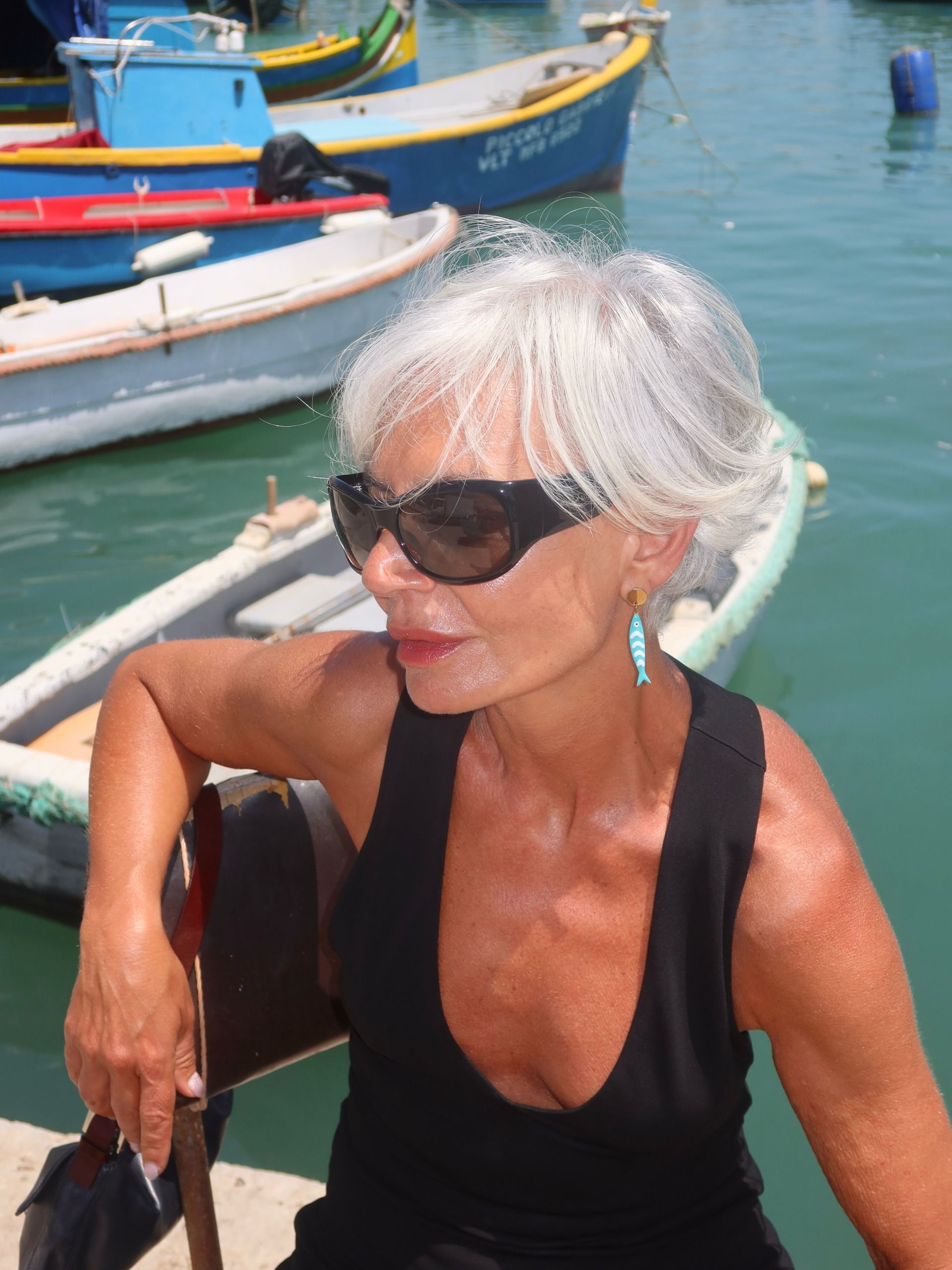 Grece Ghanem wearing black sunglasses and a tank top.