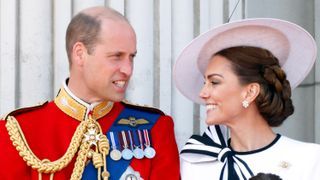 Prince William and Catherine, Princess of Wales smile at each other as they watch an RAF flypast from the balcony of Buckingham Palace after attending Trooping the Colour on June 15, 2024