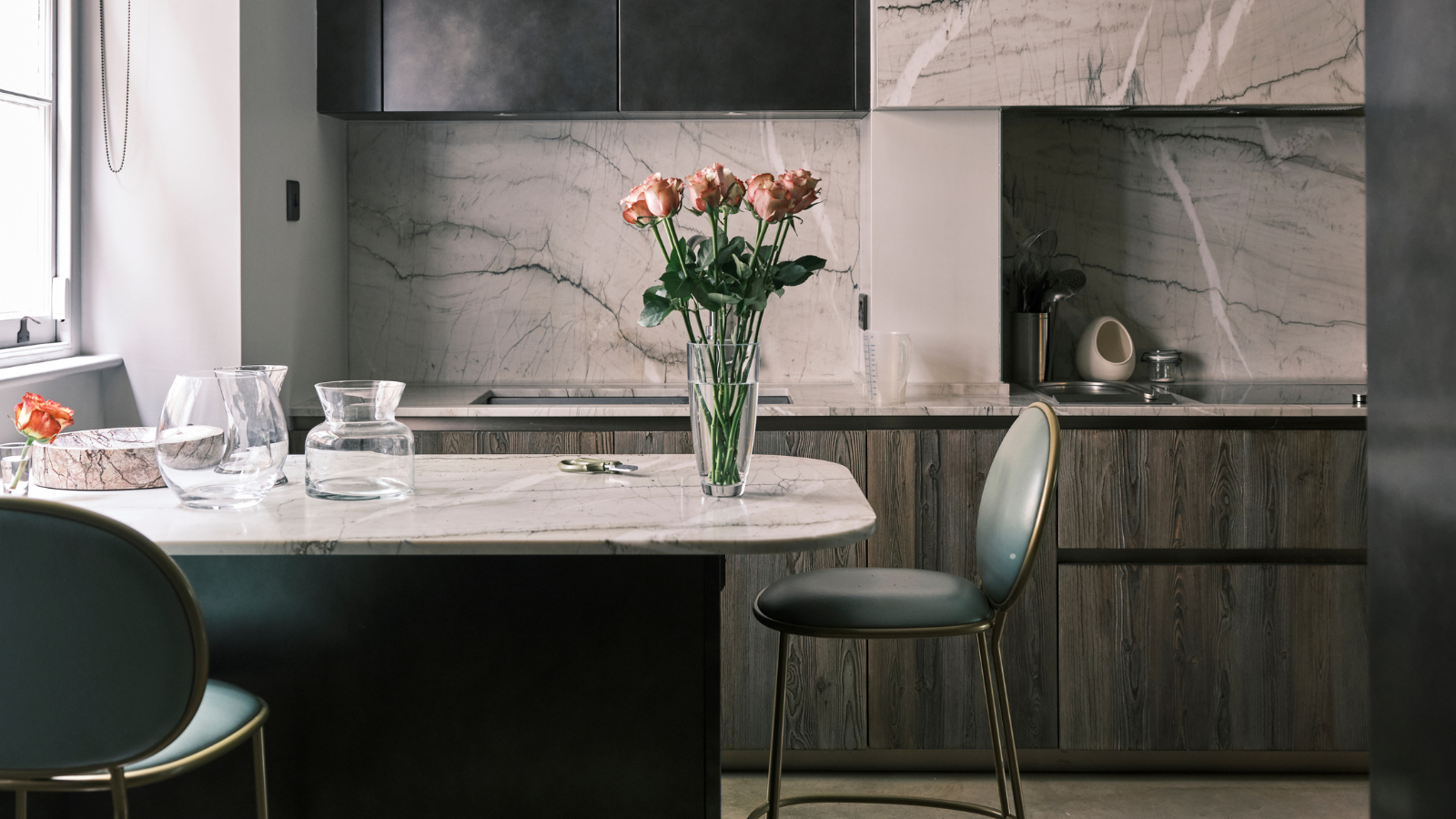 Dark kitchen with dark wood cabinets and flowers on the peninsula