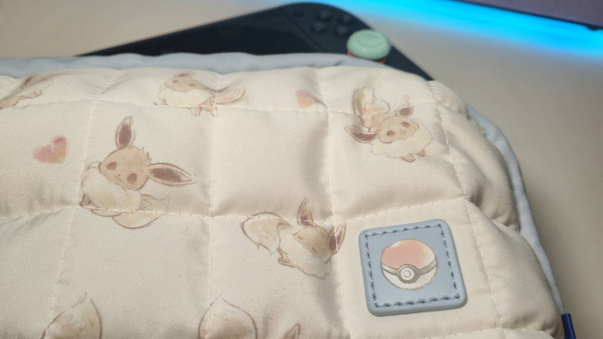 Photo of a Switch 2 poking out from the Eevee Cottage Core pouch.
