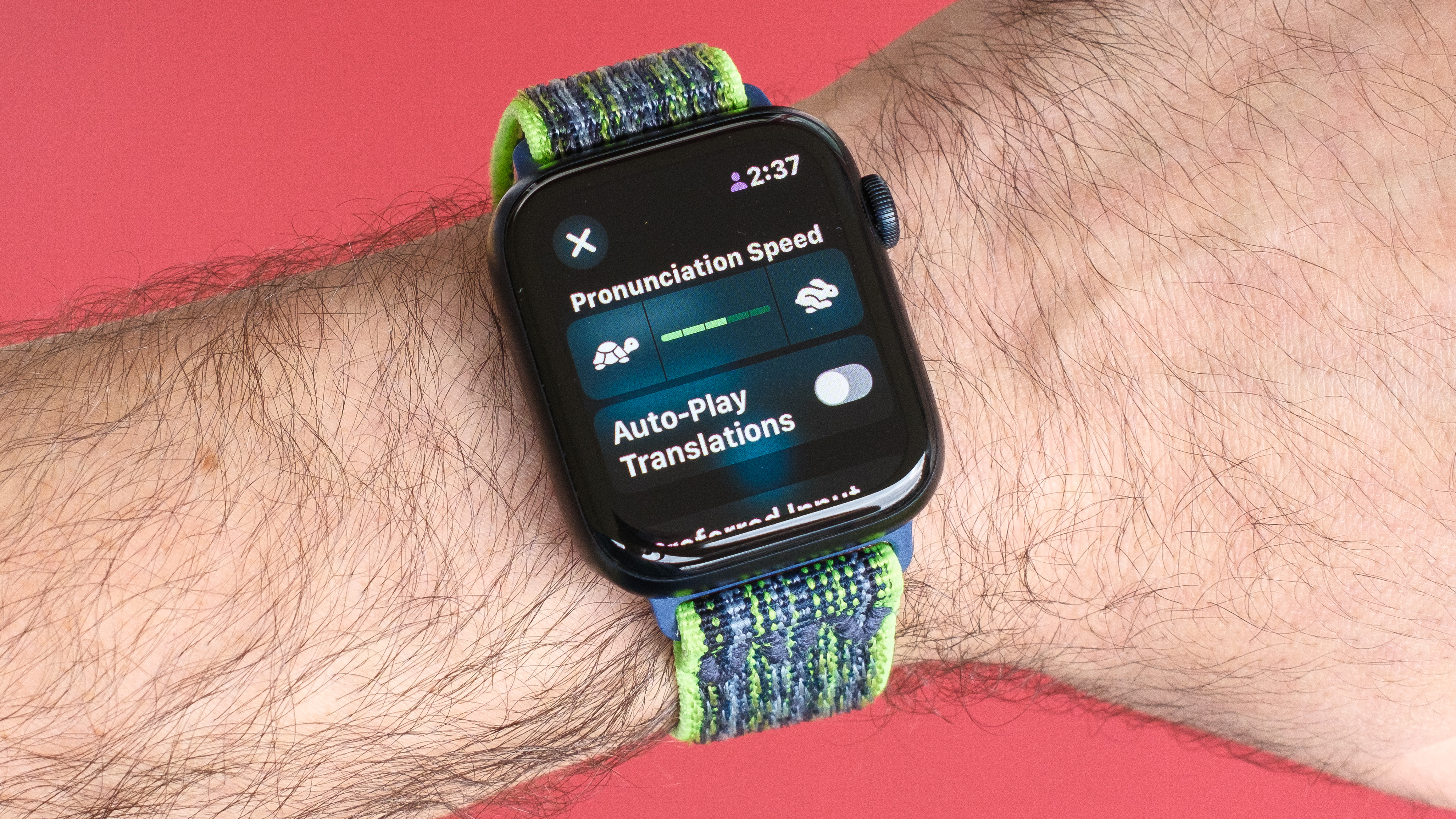 Close-up of an Apple Watch SE 2022 against a red background with the new Translate app on the screen