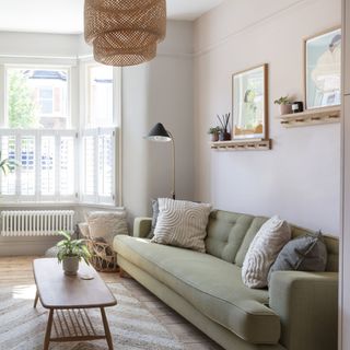 living room with bay window, green sofa and wooden coffee table