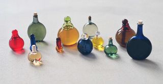 multiple multi-colour handblown glass bottles of skincare products by Kindred Black
