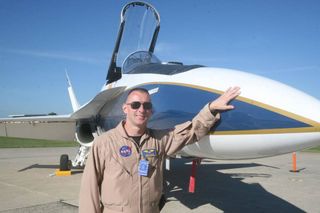 NASA research pilot Jim "Clue" Less stands next to an F/A-18 that he is flying to help test low-boom flight research.