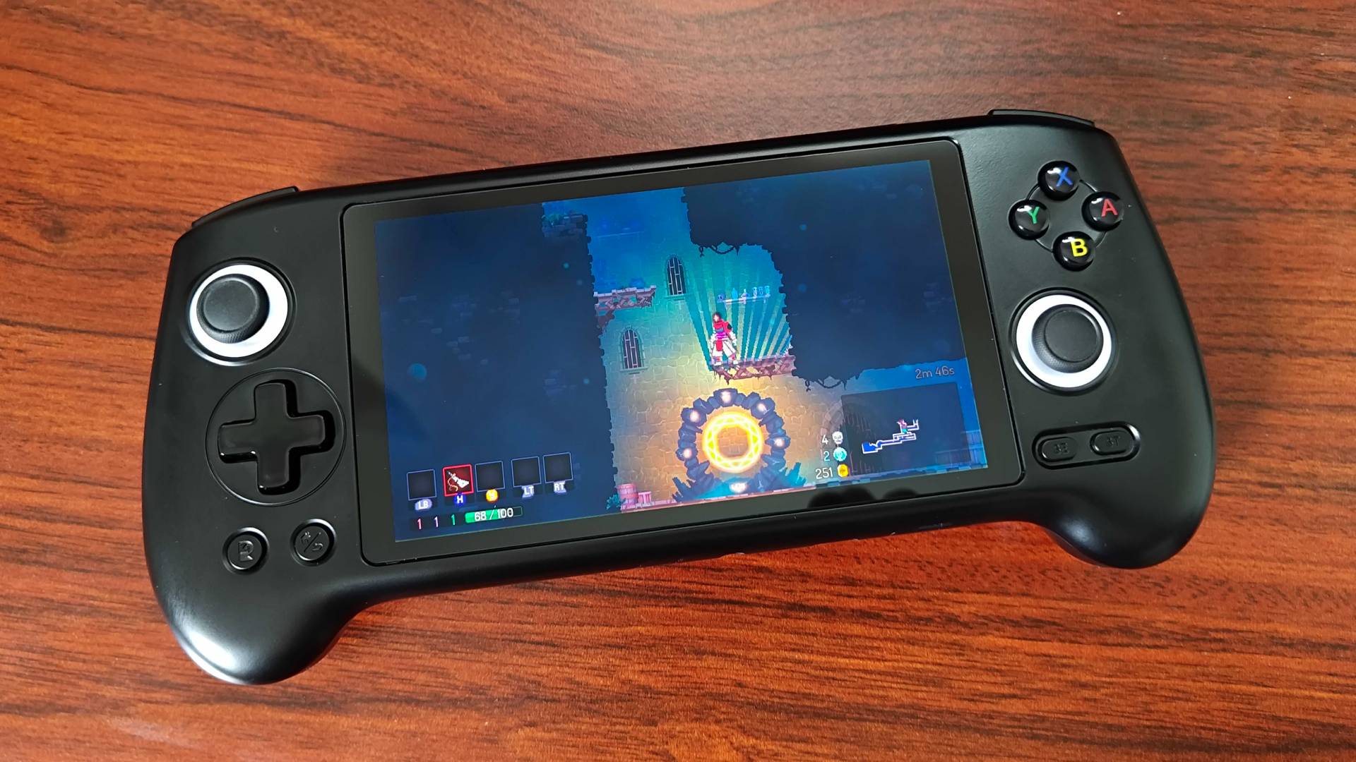Anbernic RG556 handheld with Dell Cells gameplay on screen.