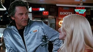 Kurt Russell in a silver jacket talking to a blonde woman in Death Proof