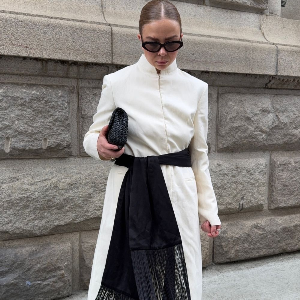 @dinahansen wears a black fringe scarf with a white wool coat, black clutch and sunglasses 