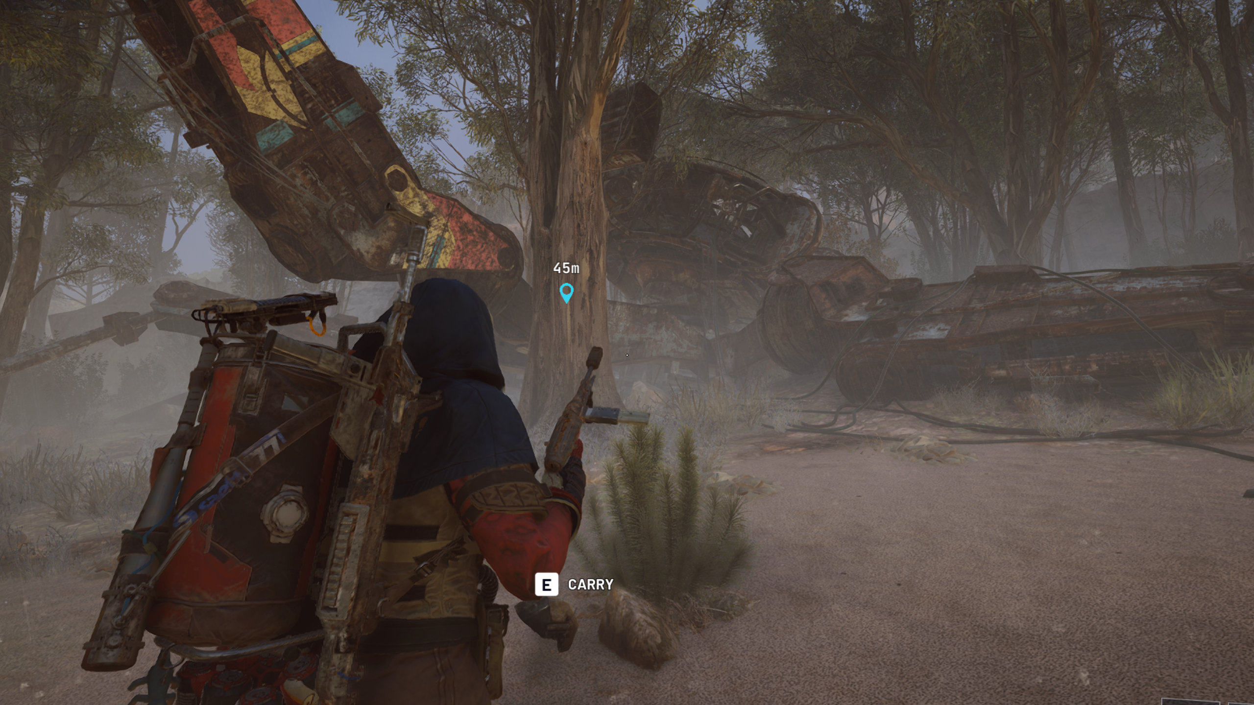 Arc Raiders Keeping the Memory: A player looking at a tree next to a large machine wreck covered in graffiti.