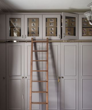 room with white cupboard and wooden ladder