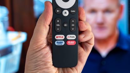 PLEIO (Freely) remote control in front of TV showing Gordon Ramsey's Kitchen Nightmares