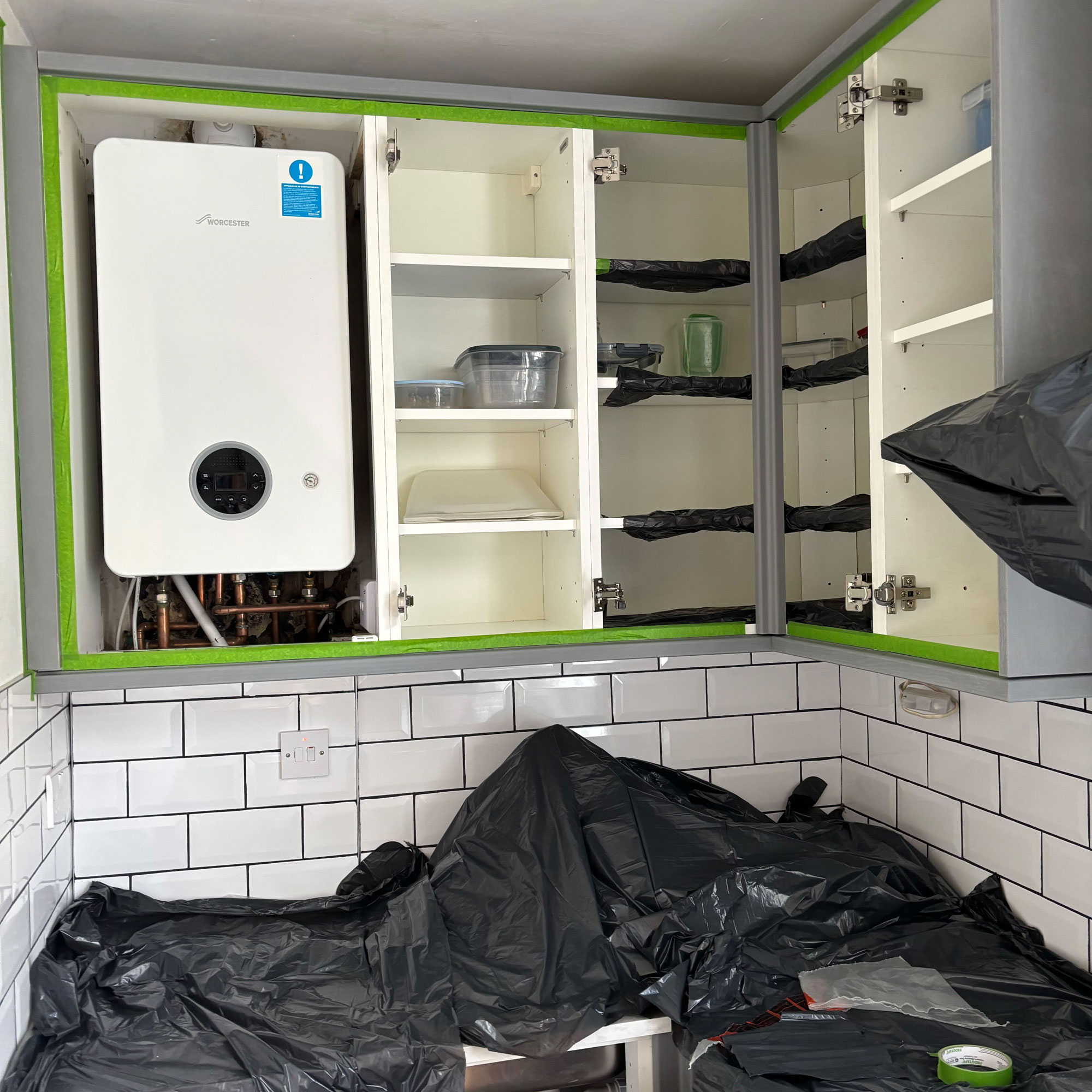 Green painted kitchen with gold handles and white countertops