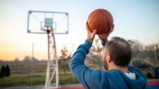 Mature man playing basketball on sports court