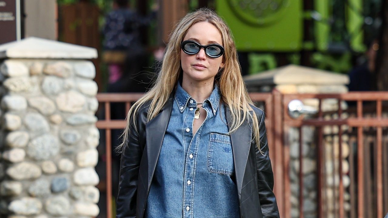 Jennifer Lawrence Wearing a denim shirt with a leather blazer and blue-tinted sunglasses