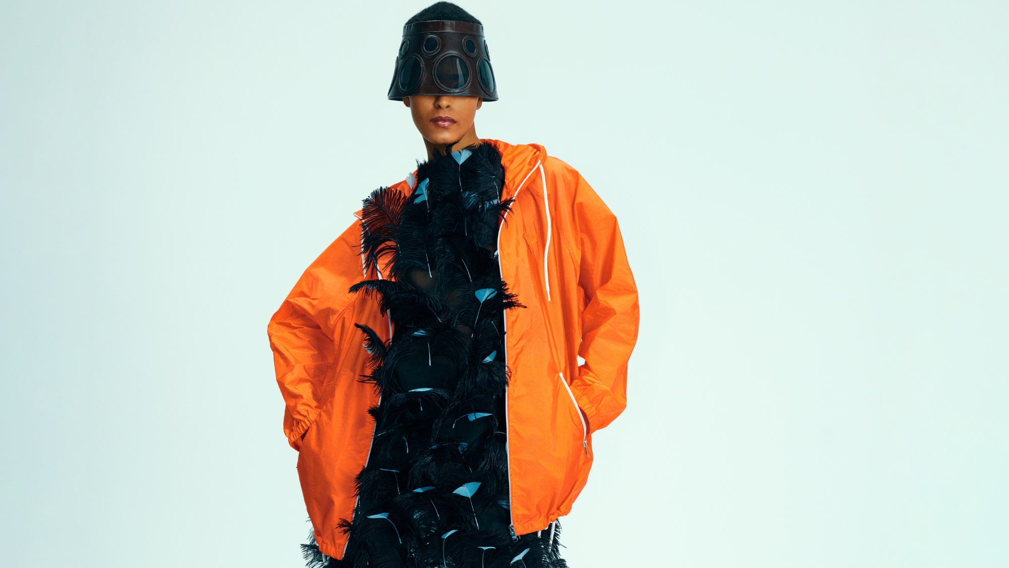 Model wearing a feather dress with orange nylon jacket