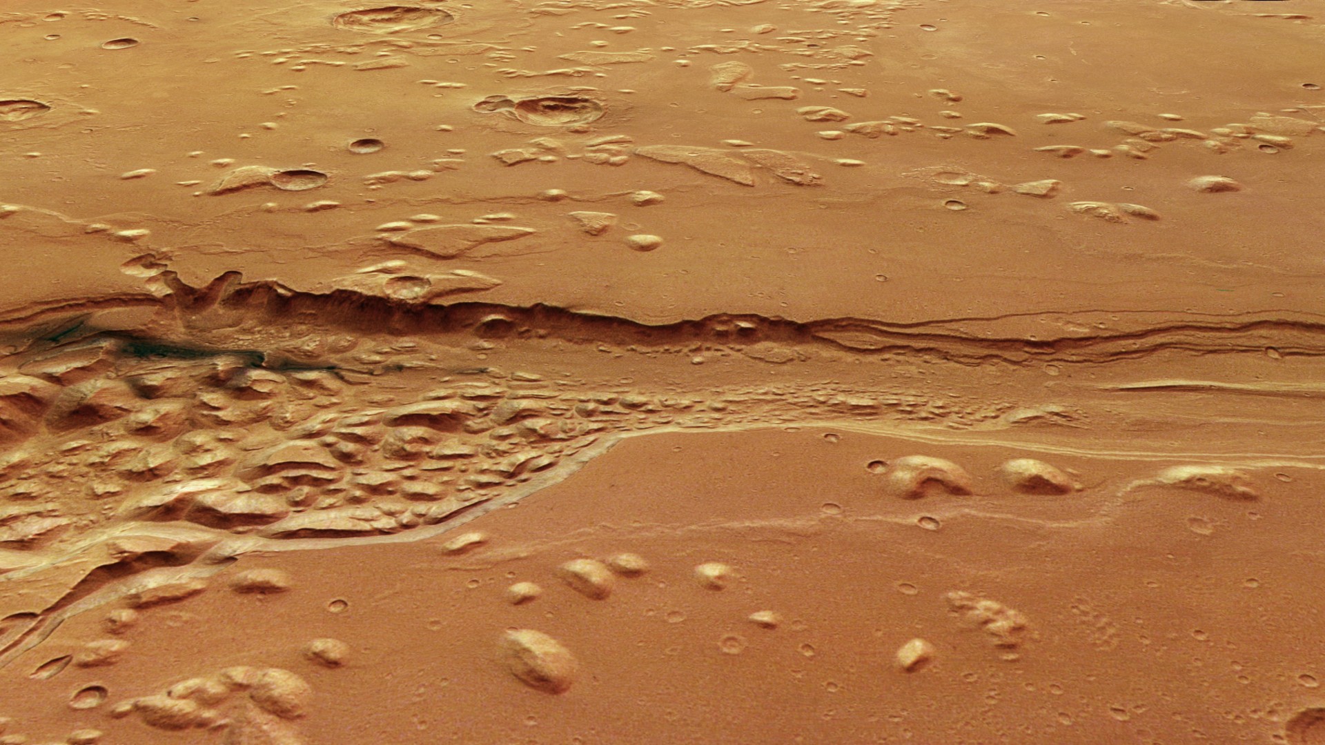a deep, ragged trench carved into a reddish-orange landscape