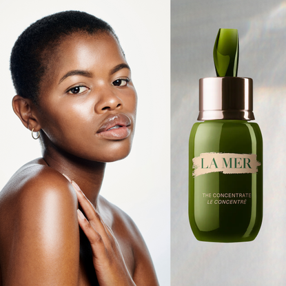 A woman with glowing skin looking over her shoulder and looking into the camera. She is next to a bottle of skincare serum.