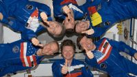 International Space Station Expedition 20 crew members give a "thumbs-up" signal as they pose in "star-burst" formation in the Harmony node. Pictured clockwise from the bottom (center) are Gennady Padalka, Tim Kopra, Robert Thirsk, Roman Romanenko, Frank De Winne and Michael Barratt.