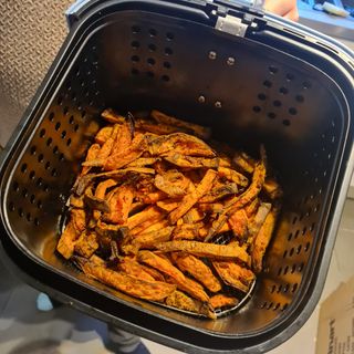 Close up of sweet potato fries cooked in the basket of a Swan Retro air fryer