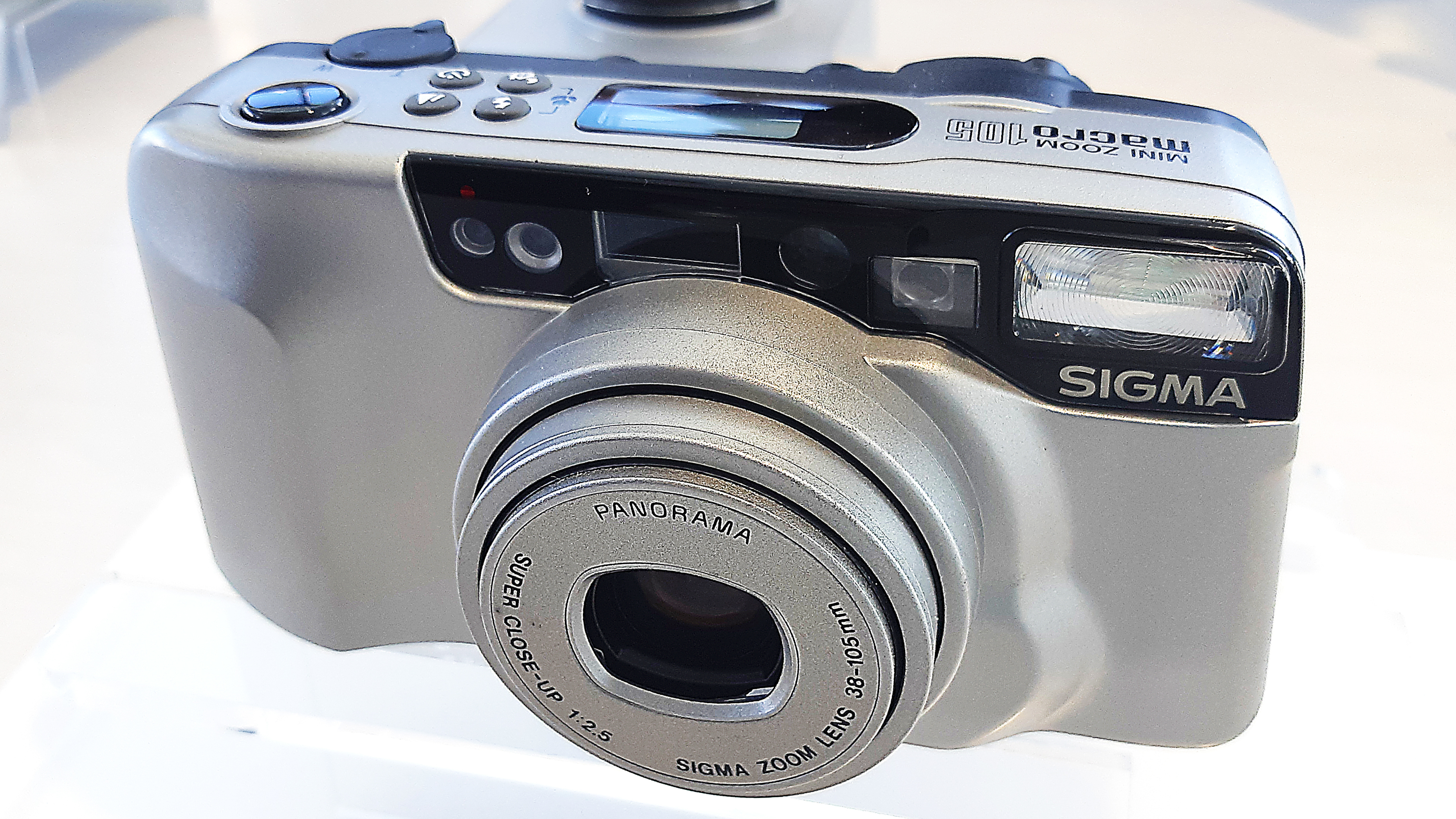 Sigma Mini Zoom 105 Macro (1994). Fully automatic 35mm compact with 38-105mm f/2.5 autofocus zoom and a 13-36mm panorama mode.