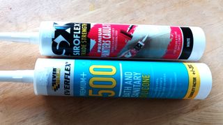 Two tubes of caulk and silicone on wooden background