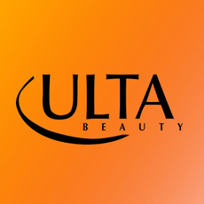 Beauty products from multiple brands on pile of notebooks and folders with orange and yellow background.